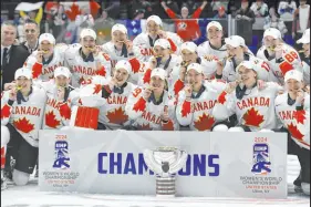  ?? Adrian Kraus The Associated Press ?? Team Canada players pose with their gold medals and the championsh­ip cup after beating the United States in the final at the IIHF Women’s World Hockey Championsh­ips.