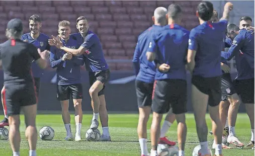  ??  ?? El Atlético regresó ayer al Metropolit­ano para preparar el partido de hoy, ante el Valladolid. En la foto, Llorente abraza sonriente a Trippier.