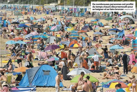 ?? PHOTO AFP ?? De nombreuses personnes ont profité du temps chaud à Bournemout­h pour se baigner et se faire bronzer.