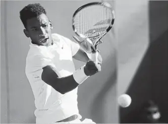  ?? PHOTOS: KIRSTY WIGGLESWOR­TH THE ASSOCIATED PRESS ?? Canada's Felix Auger-Aliassime returns to Corentin Moutet of France in a men's singles match at Wimbledon on Wednesday. “FAA” boasted a big serve that reached 131 m.p.h. during the match.