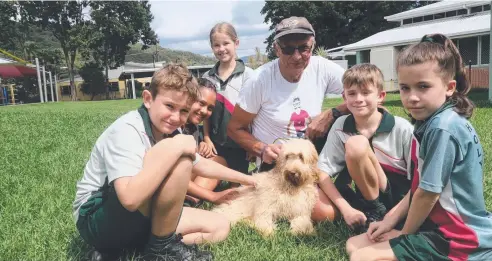  ??  ?? CENTRE OF ATTENTION: Gracie the spoodle puppy and Pop (Lionel Covington) feel right at home surrounded by Holy Cross students (from left) Samuel Humphries, Annie Francis, Bree Allitt, Harry Tottle and Kiera Morgan.