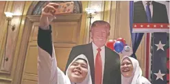  ??  ?? KUALA LUMPUR: Malaysian Muslim school girls pose for a selfie with a cutout of US President-Elect Donald Trump during an event to follow the election results yesterday. — AFP