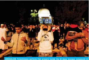  ??  ?? JERUSALEM: Palestinia­ns perform Fajr prayers inside the Al-Aqsa mosque compound in Jerusalem’s Old City yesterday after a two-month closure. — AFP