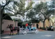  ?? GERALD HERBERT — THE ASSOCIATED PRESS ?? This photo shows a horse and carriage in front of The Windsor Court Hotel in New Orleans. Hotels are getting in on royal wedding mania and Windsor Court Hotel has a royal wedding-themed package priced at $51,918. The numbers match the May 19 date of...