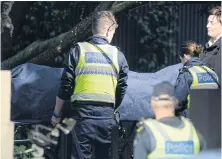  ?? AFP ?? Police officers help the coroner remove a body at the scene of a hostage situation in the Melbourne bayside suburb of Brighton.