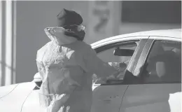  ?? DAVID ZALUBOWSKI/AP 2021 ?? A medical technician performs a nasal swab test on a motorist last month in Denver.