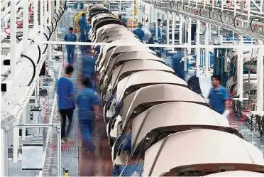  ?? — Reuters ?? Market potential: Employees work along a Geely assembly line in Zhejiang province June. Geely believes Saxo Bank’s technologi­es and product value can be expanded across Asia.