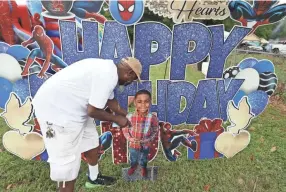  ?? JOE RONDONE/THE COMMERCIAL APPEAL ?? Marvin Coleman reposition­s a photo cutout of his grandson, Laterius "TJ" Williams, during a community gathering on what would have been the child's 10th birthday. TJ died just weeks prior playing the Tiktok Blackout Challenge
according to the family.