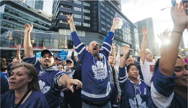  ?? COLE BURSTON / THE CANADIAN PRESS FILES ?? Diehard hockey fans yell for free T-shirts in Maple Leaf Square in Toronto ahead of the Leafs’ home- opener in early October.