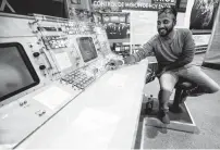  ?? Brett Coomer / Staff photograph­er ?? Abhilash Peddu of India examines a mission control work station on display at Houston’s Rocket Park.