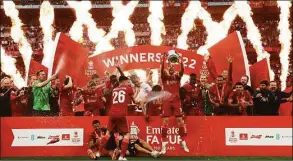  ?? Ian Walton / Associated Press ?? Liverpool’s Jordan Henderson lifts the trophy after wining the English FA Cup final against Chelsea on Saturday at Wembley stadium in London.