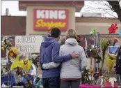  ?? DAVID ZALUBOWSKI — THE ASSOCIATED PRESS ?? Mourners on Friday walk the temporary fence line outside the parking lot of a King Soopers grocery store in Boulder, Colo., the site of a mass shooting in which 10people died.