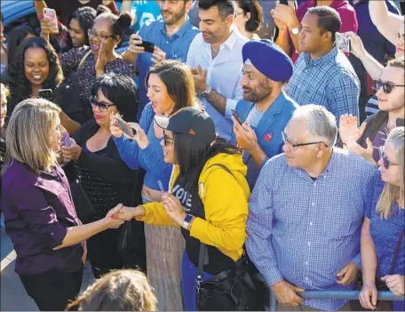  ?? Jay L. Clendenin Los Angeles Times ?? KATIE HILL, left, greets supporters as she arrives at the Newhall Family Theatre for a rally with fellow Democrat Gavin Newsom.