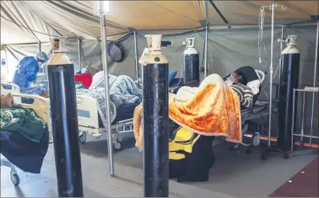  ?? JEROME DELAY - ASSOCIATED PRESS ?? COVID-19 patients are being treated with oxygen at the Tshwane District Hospital in Pretoria, South Africa, on Friday. Health Minister Zweli Mkhize this week said South Africa could run out of available hospital beds within the month.