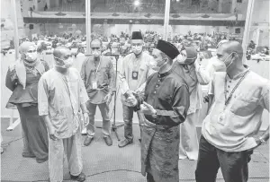  ?? — Gambar Bernama ?? PRIHATIN: Dr Mohd Azman (dua kanan) bertanya sesuatu kepada seorang pesakit sempena tinjauan di Pusat Kuarantin dan Rawatan COVID-19 Berisiko Rendah (PKRC) Negeri Kelantan semalam.