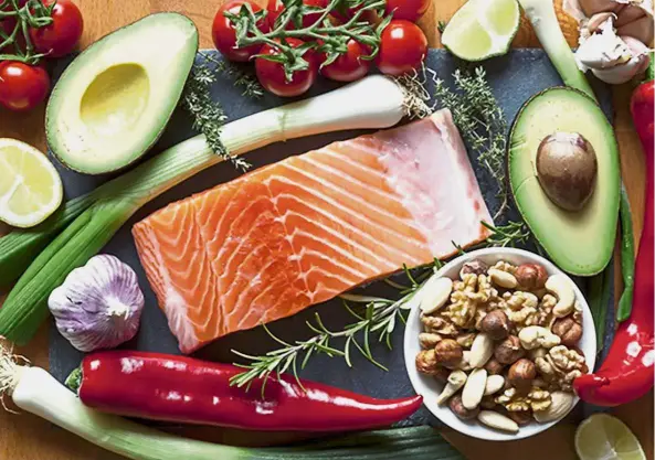  ??  ?? Highly beneficial: Foods high in healthy fats such as salmon, nuts and avocados with vegetables and herbs.