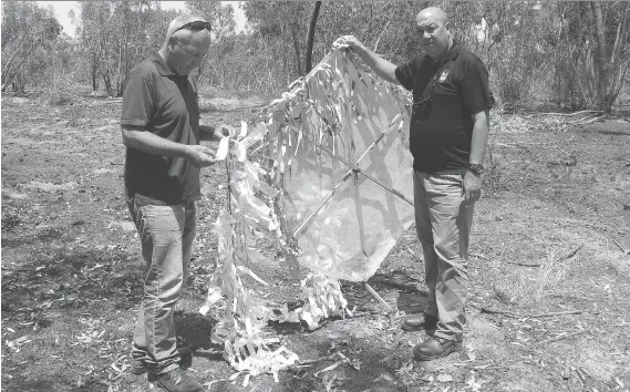  ?? RUTH EGLASH/THE WASHINGTON POST ?? Daniel Ben David, regional director of the Israeli Jewish National Fund, and Erez Shtein, the group’s northern director, hold up the remains of an incendiary kite that was flown across the border from the Gaza Strip. The Israeli army says Palestinia­ns...