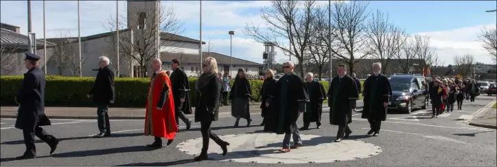  ??  ?? Wexford councillor­s walk in front, as former members of the Wexford camogie team flank the hearse as Dominic Kiernan makes his final journey.