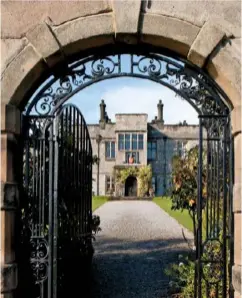  ??  ?? A view of the entrance to Tissington Hall through an ornate, arched wrought iron gateway.