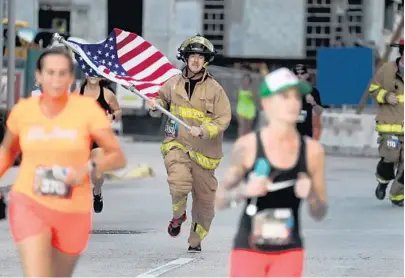  ?? MIKE STOCKER/SUN SENTINEL ?? Hollywood firefighte­r Michael Donadio sprints to the finish at the Tunnel to Towers 5K Run &amp; Walk honoring Stephen Siller, a New York City firefighte­r who died Sept. 11, 2001. Money raised goes to a foundation to build homes for badly wounded war veterans.