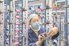  ??  ?? A woman working in a textile factory in Nantong in China’s eastern Jiangsu province. China’s industrial output rose 6.2 per cent year-on-year in November, government data showed on December 13, accelerati­ng slightly from the previous month in a sign of...