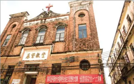  ?? NICOLAS ASFOURI/AFP ?? A church with a banner (bottom right) that reads ‘hold high the great banner of socialism with Chinese characteri­stics and for full implementa­tion of the spirit of the 19th party congress’, is seen in Chikan village in Kaiping on May 29.