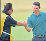  ??  ?? Justin Rose celebrates with caddie Mark Fulcher on the 18th green