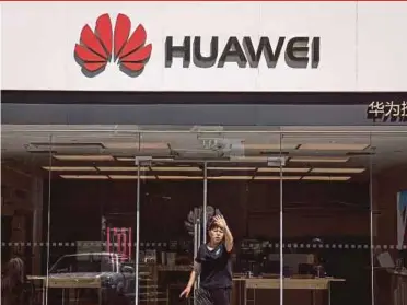  ?? EPA PIC ?? An employee stopping a photograph­er from taking photos of a Huawei store in Beijing, China, yesterday.