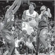  ?? NWA Democrat-Gazette/ANDY SHUPE ?? floats in the air as he drives to the basket between two Missouri defenders Saturday during the Razorbacks’ 65-63 victory over the Tigers in Fayettevil­le.