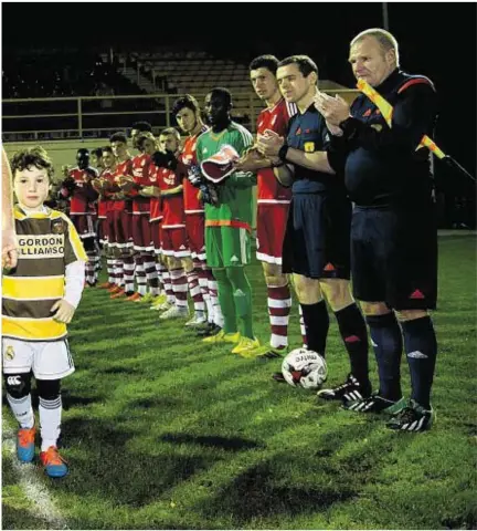  ??  ?? five-year-old son Ellis, is applauded on to the pitch before his testimonia­l match against Aberdeen