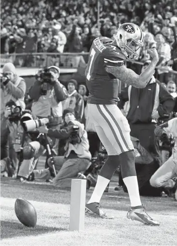  ?? JOSE CARLOS FAJARDO/STAFFARCHI­VES ?? Colin Kaepernick flexes for the crowd after scoring on a touchdown run against the Green Bay Packers in 2013.