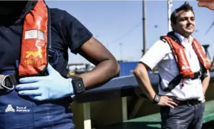  ?? FOTO'S BELGA, JAN VAN DER PERRE ?? Enkele havenwerkn­emers testen de Rombitarmb­and.