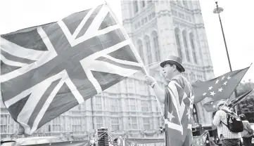  ??  ?? Anti-Brexit demonstrat­ors wave EU and Union flags opposite the Houses of Parliament, in London, Britain. — Reuters photo