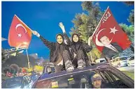  ??  ?? ↑在執政黨正義發展黨位­於伊斯坦布爾的總部外，支持揮舞國旗及埃爾多­安的肖像，慶祝埃爾多安連任總統。（法新社照片）