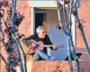  ?? REUTERS ?? Danny Wertheimer plays the guitar and sings to his neighbours from n
his balcony in Oakland, California.