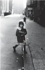  ??  ?? Diane Arbus, Girl with schoolbook­s stepping onto the curb, N.Y.C., 1957