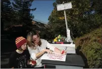  ?? RAY CHAVEZ STAFF PHOTOGRAPH­ER ?? Sarah David and daughter Maddie David, 11, of Lafayette, write a sympathy message Saturday for the victims of a shooting at an Airbnb rental house on Lucille Way in Orinda. The shooting killed five people and wounded several others at a Halloween party Thursday night.