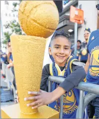  ?? AP PHOTO ?? Brandon Singh waits with his trophy for the parade to start in honor of the NBA basketball champion Golden State Warriors Tuesday in Oakland, Calif.