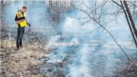  ?? ALEX LUPUL SPECIAL TO THE ST. CATHARINES STANDARD ?? Bailey Cole, an ecosystem restoratio­n student from Niagara College, assists with a controlled burn at Malcolmson Eco-Park on Monday.