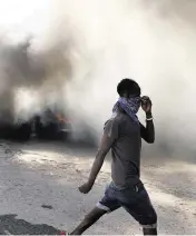  ?? ODELYN JOSEPH AP | Jan. 18, 2024 ?? In Port-au-Prince, a man walks past tires that were set on fire by protesters to call attention to Haiti’s security crisis.