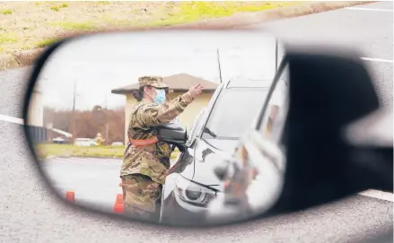  ?? MARK HUMPHREY/AP ?? A National Guard member directs motorists waiting in line at a COVID-19 vaccinatio­n site last week in Shelbyvill­e, Tennessee.