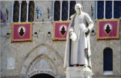  ?? GIUSEPPE CACACE/AFP ?? A statue of priest Sallustio Bandini at Piazza Salimbeni, the headquarte­rs of the Monte dei Paschi di Siena bank in Tuscany.