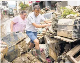  ?? AP PHOTOS ?? Priest Joerg Meyrer walks over debris in Bad Neuenahr-Ahrweiler, Germany, on Monday. More than 180 people died when heavy rainfall turned tiny streams into raging torrents across parts of western Germany and Belgium.