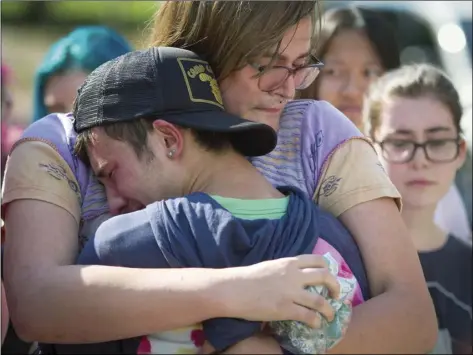  ??  ?? In this Sept. 17 photo, mourners hug at a memorial for Georgia Tech student Scout Schultz in Atlanta, Ga. Schultz was a 21-year-old who was shot and killed during a confrontat­ion with police on campus, Saturday.