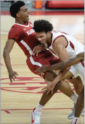  ?? (NWA Democrat-Gazette/Andy Shupe) ?? Arkansas senior forward Justin Smith (right) collides with Alabama’s Herbert Jones during the No. 20 Razorbacks’ victory over the No. 6 Crimson Tide on Wednesday night at Walton Arena in Fayettevil­le. More photos available at arkansason­line.com/225alaua.