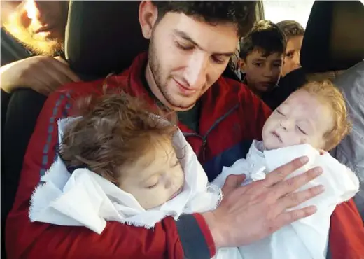  ??  ?? Abdul-Hamid Alyousef, 29, holds on April 4 his twin babies who were killed during a suspected chemical weapons attack in Khan Sheikhun in the northern province of Idlib, Syria. (AP)