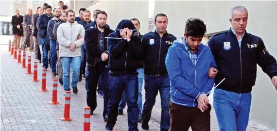  ?? Turkish police officers escort detainees after their arrest for alleged links with US-based cleric Fethullah Gulen in the central city of Kayseri. ??