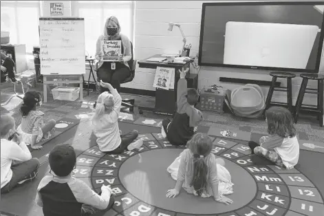  ?? LAUREN PAYTON VIA AP ?? IN THIS PHOTO PROVIDED BY JULIE MACKETT, the kindergart­en teacher conducts her class at Ft. Meigs Elementary School, in Perrysburg, Ohio. Contact tracing and isolation protocols meant to contain the spread of the coronaviru­s are sidelining school employees and frustratin­g efforts to continue in-person learning. “I think everybody understand­s when you can’t have enough subs to fill the roles, it’s also a safety issue: You can’t have that many children without support from adults,” said Mackett, who went through her own two-week quarantine early in the school year after a student tested positive.