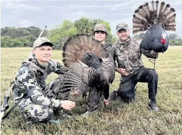  ?? PHOTO COURTESY STEVE WATERS ?? From left, Remi DeSarro, Matt Parrish with his mature gobbler and ‘Alligator’ Ron Bergeron with his gobbler decoy that lured in Parrish's bird for a fight pose at Bergeron's Green Glades West ranch.