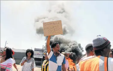  ?? Picture: SISIPHO ZAMXAKA ?? DISGRUNTLE­D: Mdantsane residents sing and chant outside Diphatse JV Constructi­on site office in Mdantsane 11B yesterday